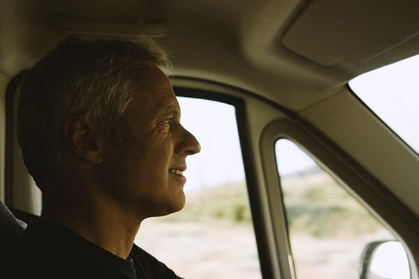 A headshot of sleep apnoea patient Dani looking happy and relaxed as he drives his motorhome to the beach in search of waves.