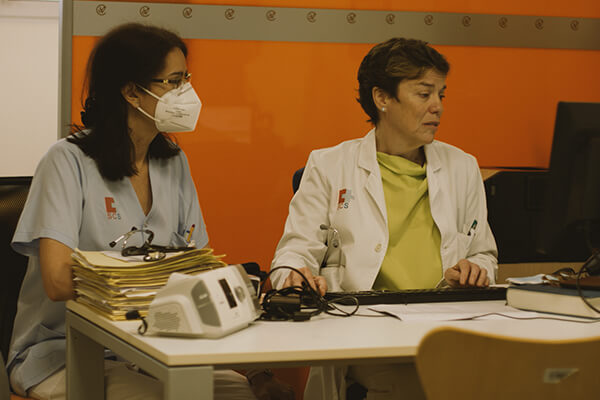 A pulmologist and member of sleep clinic staff looking at the results of a sleep study on a computer.