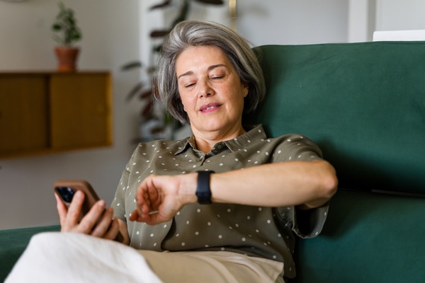  Woman looking at her apple watch and phone