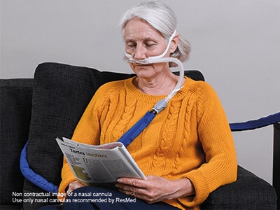 A woman receiving high-flow therapy treatment being assessed by her healthcare professional in a medical office.